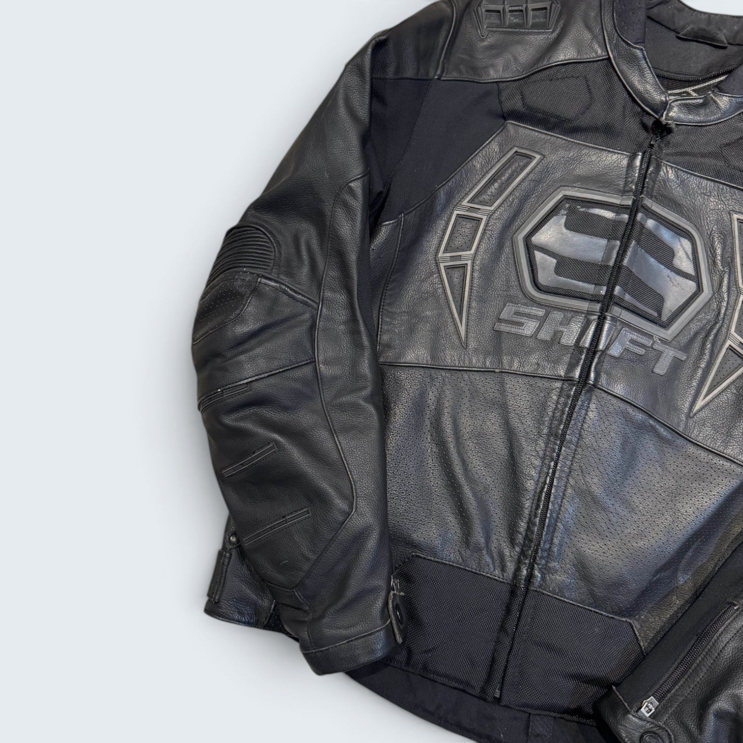 Black leather jacket with a brand logo on a light gray background