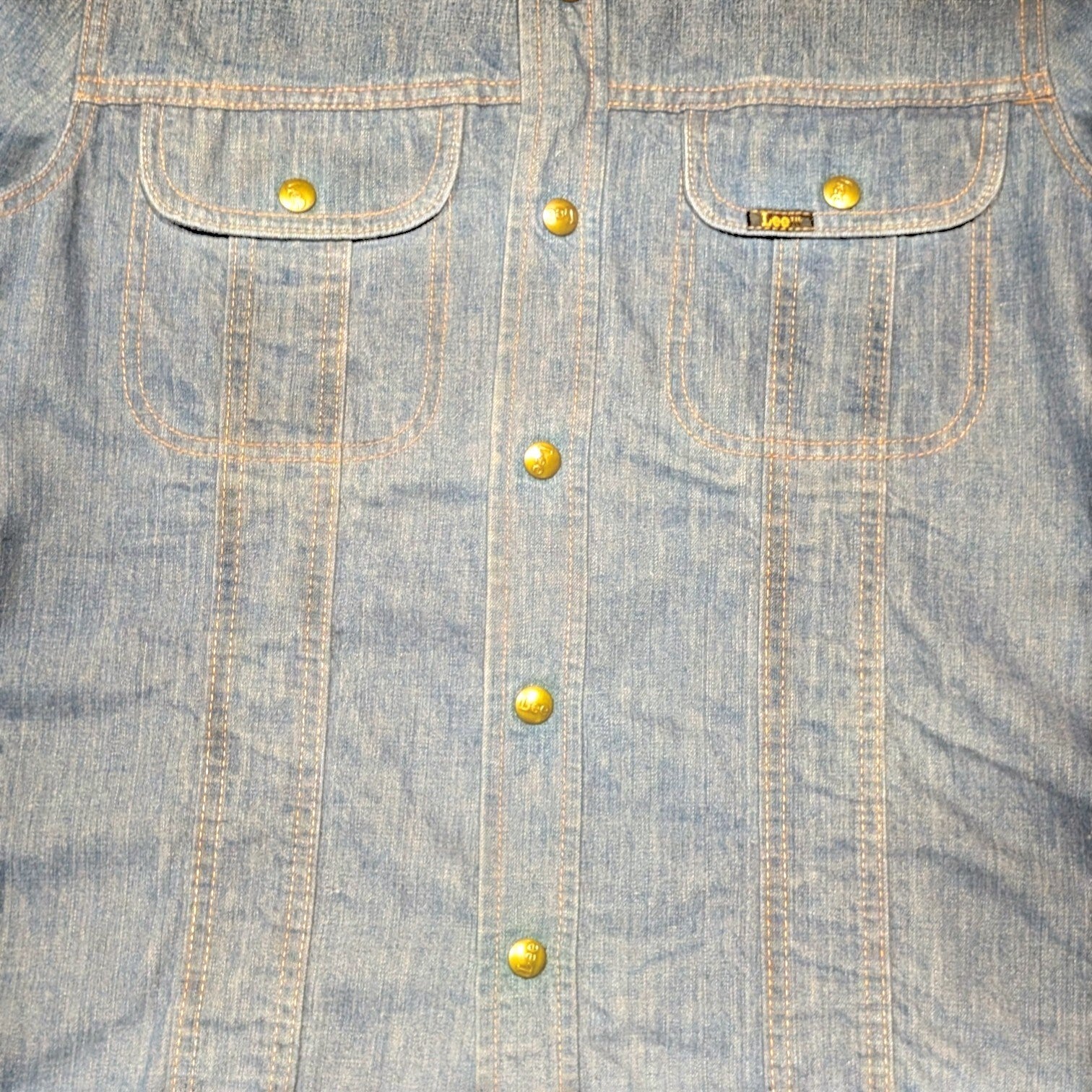 STOXX THRIFT & VINTAGE 70s Lee long denim jacket in blue with brass buttons and dual chest pockets, made in USA.