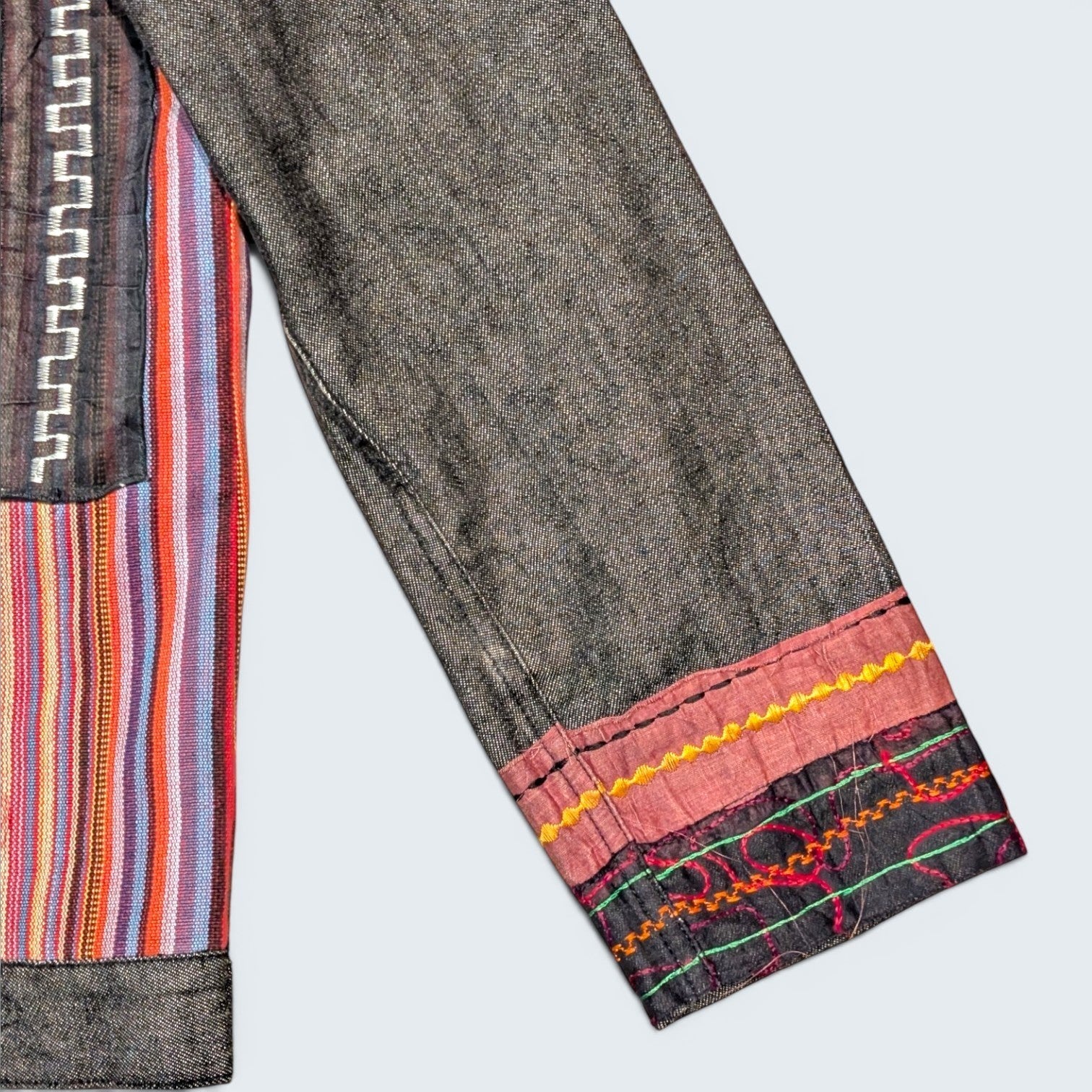 STOXX THRIFT & VINTAGE Attitude denim jacket featuring colorful striped fabric panels and decorative embroidery.