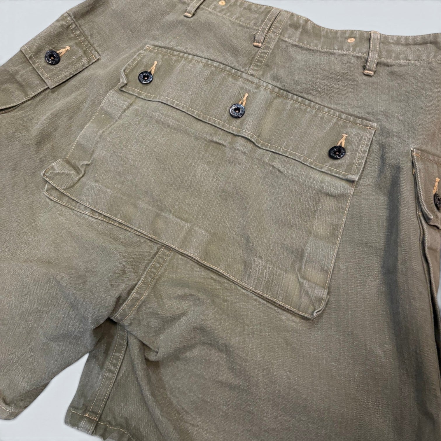 STOXX THRIFT & VINTAGE Buzz Rickson & Co. olive cotton ripstop military cargo shorts with black button details.
