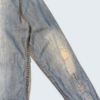 STOXX THRIFT & VINTAGE DSQUARED2 light wash denim shirt sleeve with circular patchwork and distressed paint details.