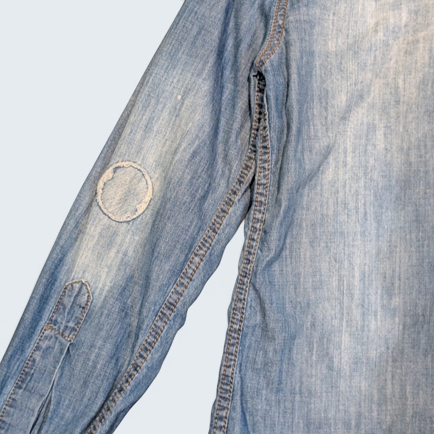 STOXX THRIFT & VINTAGE DSQUARED2 light wash denim shirt with distressed circular patchwork detail on the sleeve.