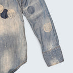 STOXX THRIFT & VINTAGE DSQUARED2 light wash denim shirt featuring circular patchwork, paint splatters, and frayed edges.