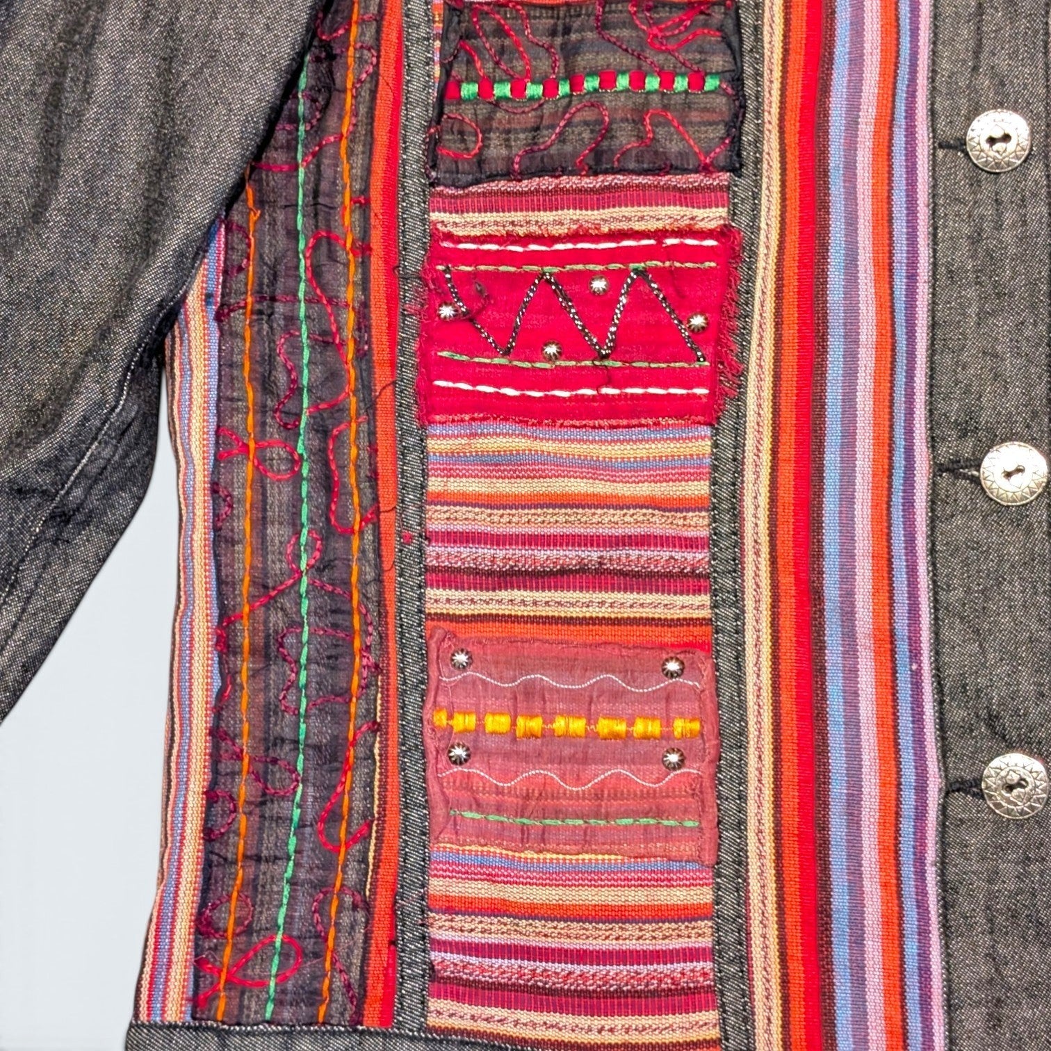 STOXX THRIFT & VINTAGE denim jacket featuring colorful embroidered patchwork panels and metallic button details.