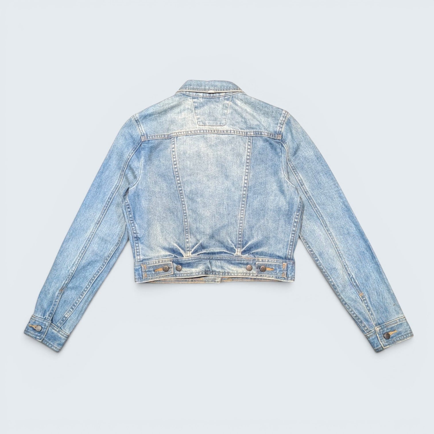Back view of a light wash blue Harley Davidson denim jacket from STOXX THRIFT & VINTAGE with button cuffs.