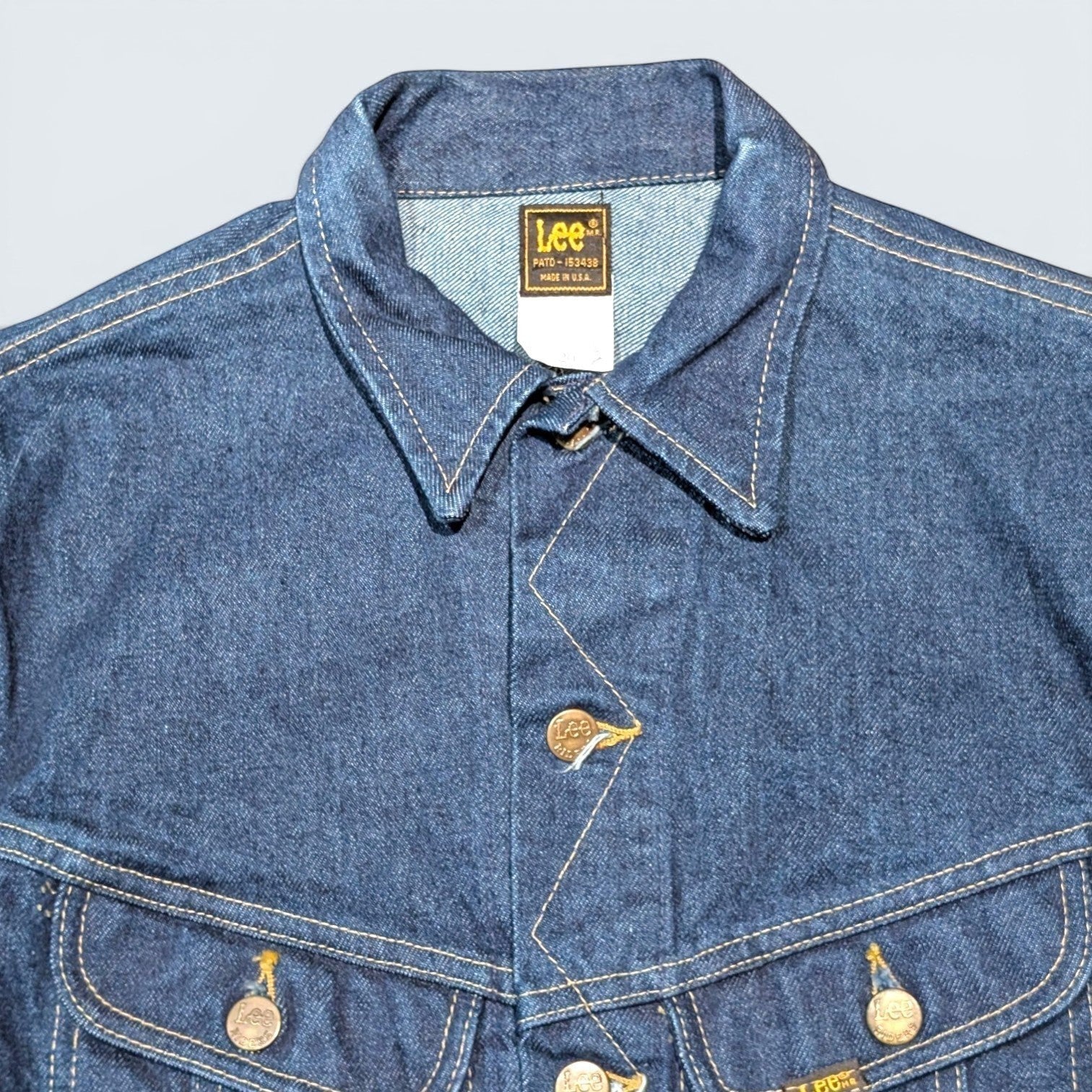 STOXX THRIFT & VINTAGE dark blue Lee denim jacket with gold contrast stitching and branded metal buttons.