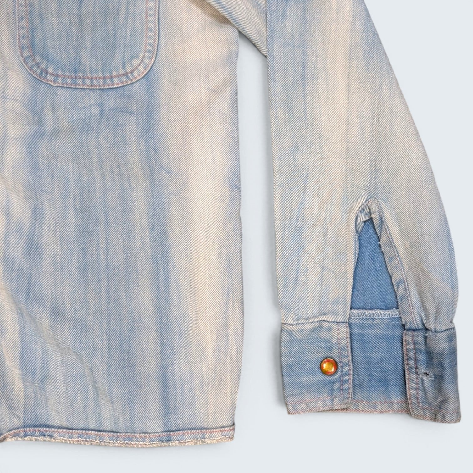 STOXX THRIFT & VINTAGE light wash denim jacket with buttoned cuffs and chest pocket detail.