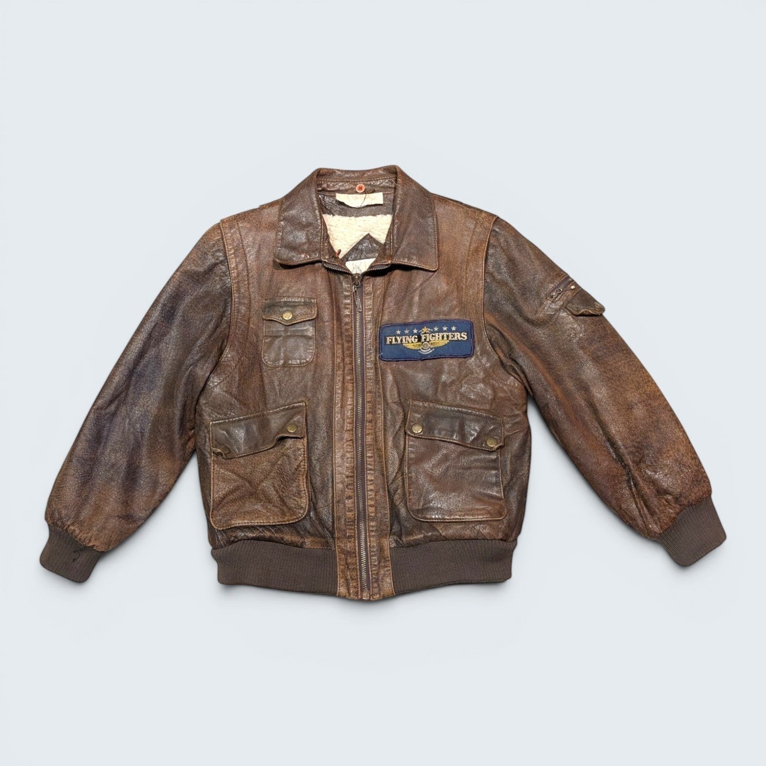 STOXX THRIFT & VINTAGE London Fog brown distressed leather bomber jacket with cream sherpa lining and fighter patch.