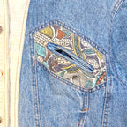 STOXX THRIFT & VINTAGE blue denim jacket featuring a unique jungle-patterned patch pocket and cream trim detail.