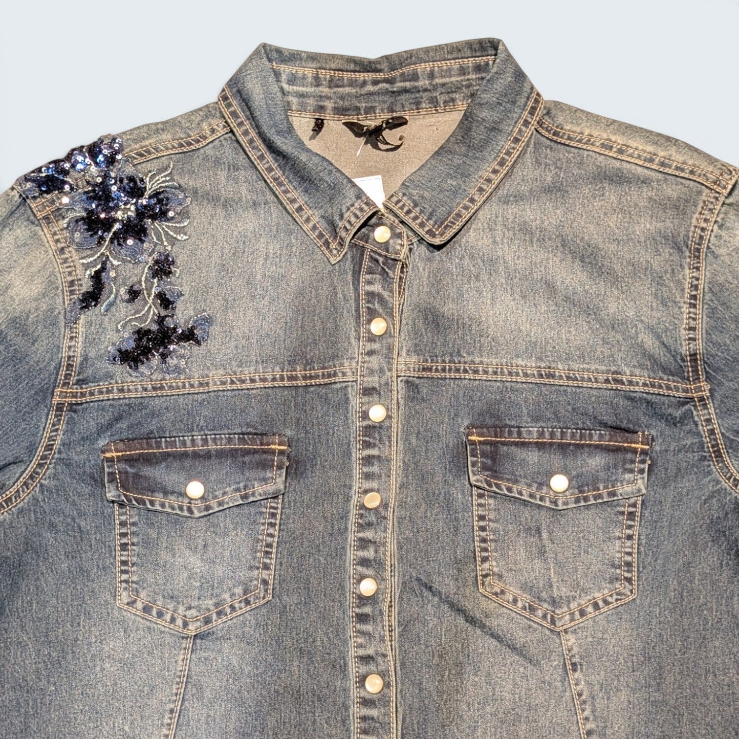 STOXX THRIFT & VINTAGE blue denim shirt featuring floral sequin embellishments on the shoulder and button-down front.