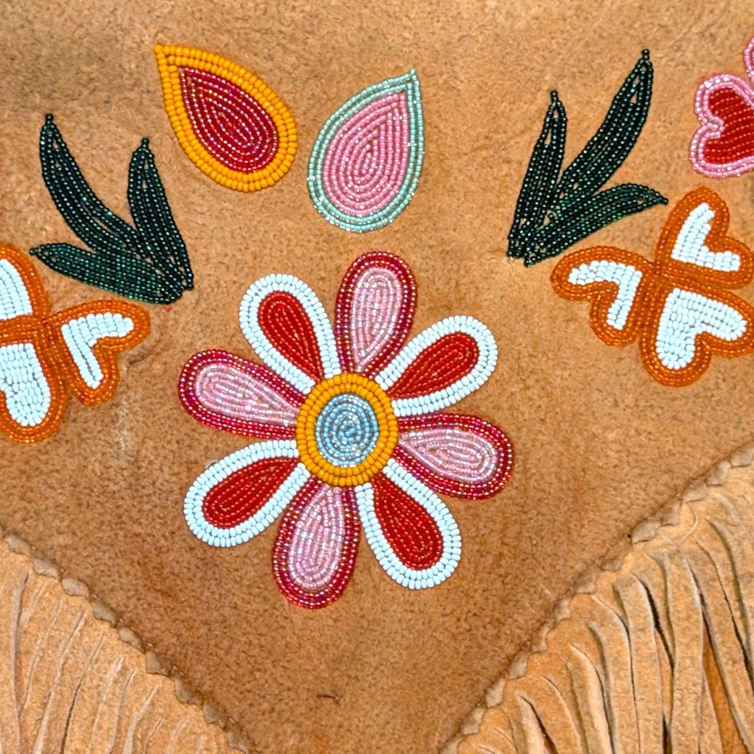 STOXX THRIFT & VINTAGE tan suede jacket featuring intricate hand-sewn floral beadwork and decorative fringe detailing.